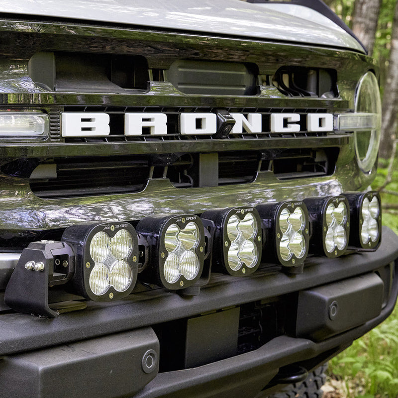 Baja Designs XL Linkable Bumper Light Kit on a Ford Bronco: six linked XL pods mounted across the front bumper of a Ford Bronco below the grille lettering