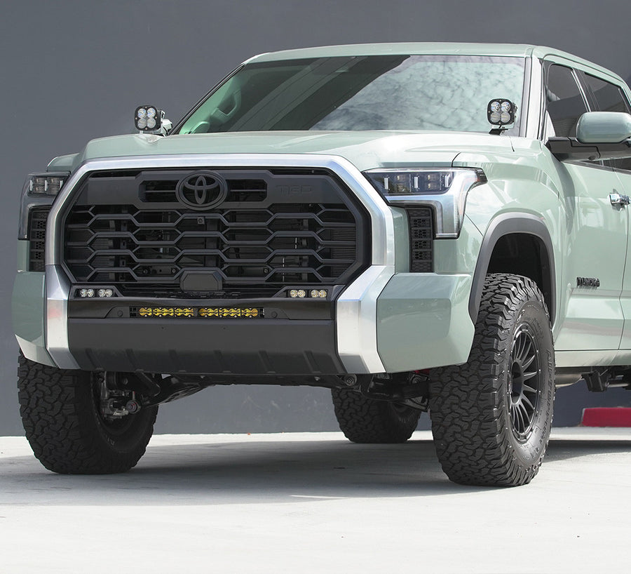 Baja Designs XL Pro A-Pillar Light Kit installed on a Toyota Tundra: A sage green Toyota Tundra parked against a gray wall with Baja Designs XL LED pods on both A-pillars