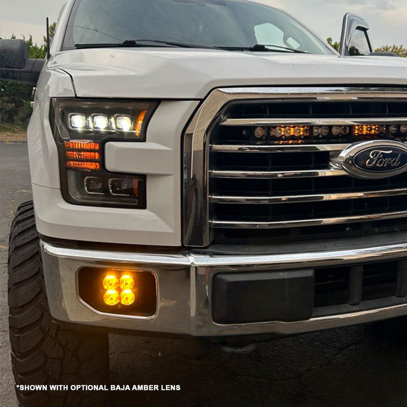 Baja Designs XL Pro Fog Pocket Kit installed on a Ford F-150: A white Ford F-150 front end with an amber Baja Designs pod glowing in the fog light pocket