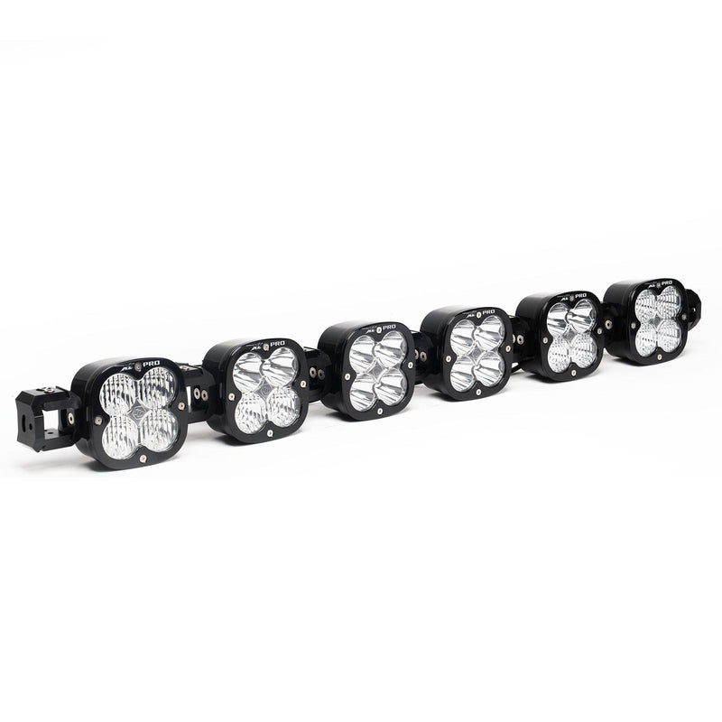 Baja Designs XL Pro Linkable LED Light Bar, whole product on a studio background: A 6-light black XL Pro Linkable LED light bar with clear lenses and end mounting blocks, shown at a front three-quarter angle on a white background