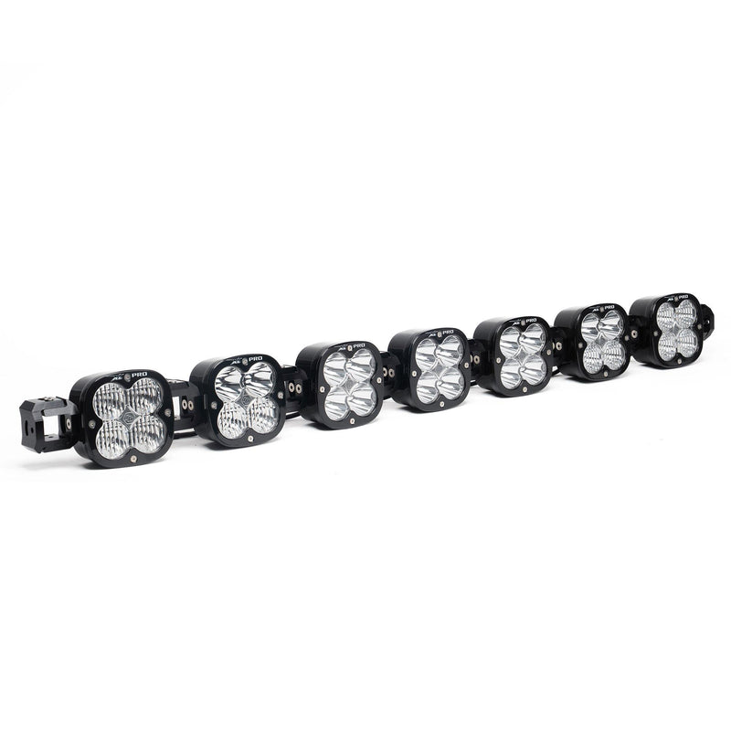 Baja Designs XL Pro Linkable LED Light Bar, whole product on a studio background: A 7-light black XL Pro Linkable LED light bar with clear lenses and end mounting blocks, shown at a front three-quarter angle on a white background
