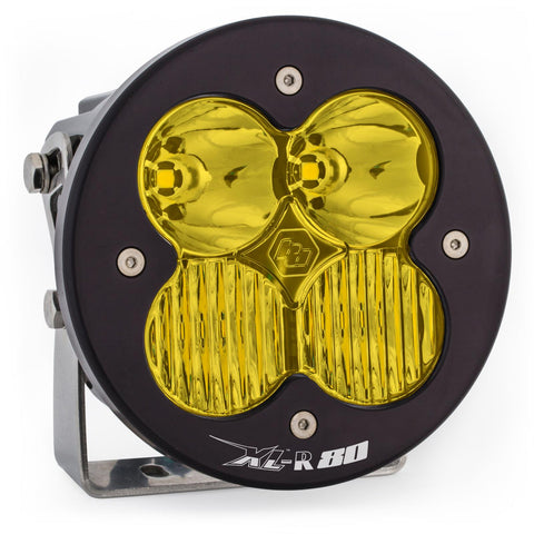 Baja Designs XL-R 80 LED Auxiliary Light Pod, whole product on a studio background: A Baja Designs round XL-R 80 pod with amber lenses shown on a white background with its mounting bracket