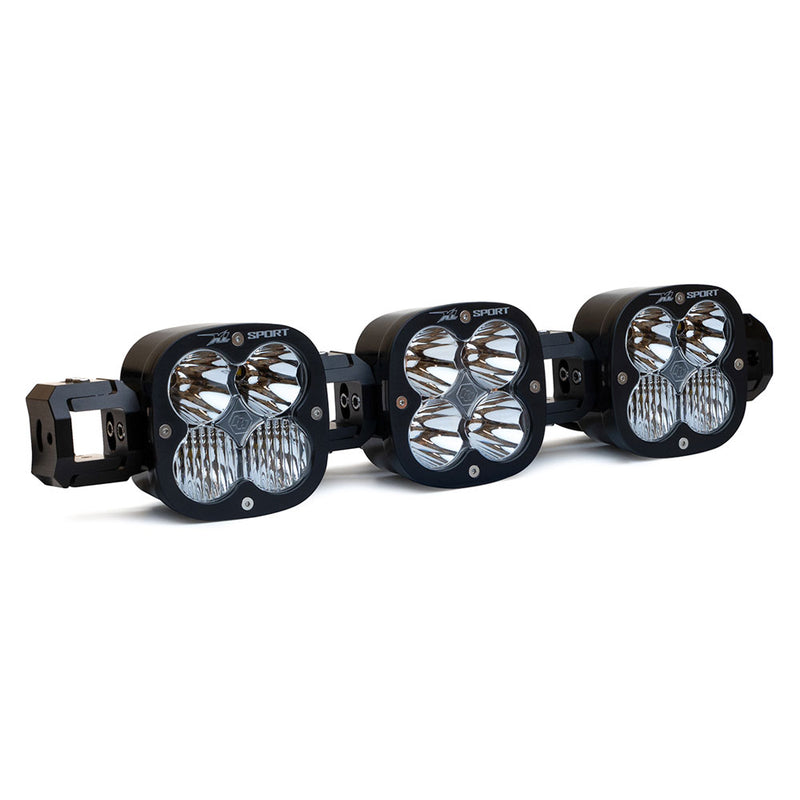 Baja Designs XL Sport Linkable LED Light Bar, whole product on a studio background: A 3-light black XL Sport Linkable LED light bar with clear lenses and end mounting blocks, shown at a close front three-quarter angle on a white background