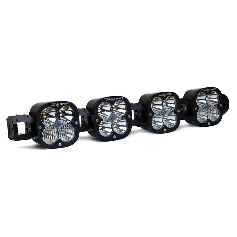 Baja Designs XL Sport Linkable LED Light Bar, whole product on a studio background: A 4-light black XL Sport Linkable LED light bar with clear lenses and end mounting blocks, shown at a front three-quarter angle on a white background