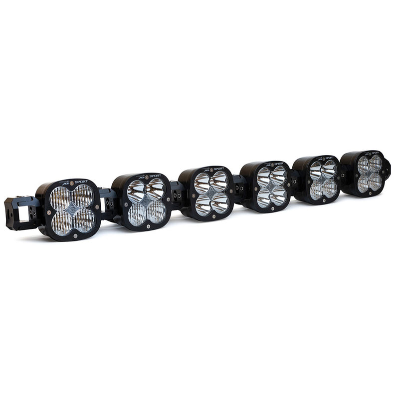 Baja Designs XL Sport Linkable LED Light Bar, whole product on a studio background: A 6-light black XL Sport Linkable LED light bar with clear lenses and end mounting blocks, shown at a front three-quarter angle on a white background