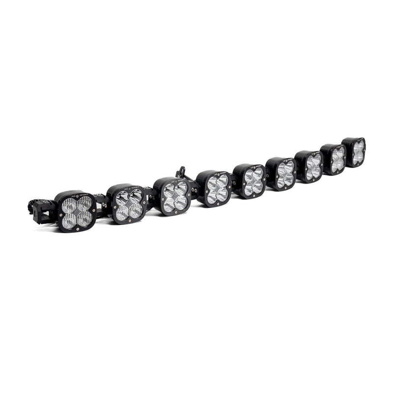 Baja Designs XL Sport Linkable LED Light Bar, whole product on a studio background: A 9-light black XL Sport Linkable LED light bar with clear lenses and end mounting blocks, shown at a angled side angle on a white background