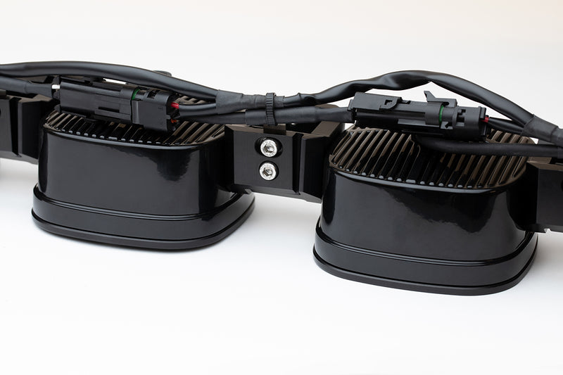 Close-up of the Baja Designs XL Sport Linkable LED Light Bar: A close rear view of two linked XL light pods showing their finned backs, joining hardware and wiring harness connectors