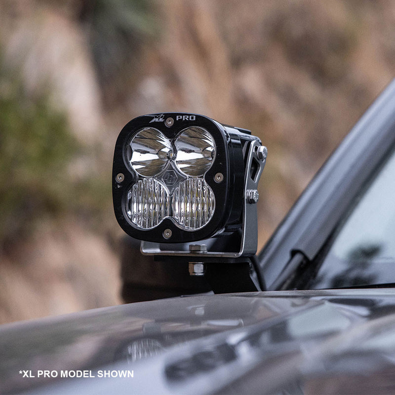 Baja Designs XL80 A-Pillar Kit on a vehicle: an XL Pro LED pod mounted on an A-pillar bracket beside a dark truck hood, with a model-shown caption