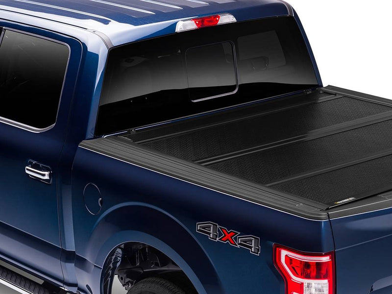 BAKFlip FiberMax hard folding tonneau cover fully closed on a blue pickup, rear three-quarter view