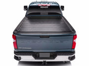BAKFlip G2 hard folding tonneau cover closed flat in matte black over the bed of a dark blue Chevrolet Silverado, seen straight on from the rear tailgate