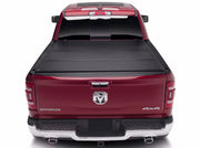 BAK BAKFlip MX4 tonneau cover closed flush across the bed of a dark red Ram 1500 Laramie viewed straight on from behind the tailgate