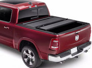 BAK BAKFlip MX4 hard folding tonneau cover in matte black closed over the bed of a dark red Ram 1500 Laramie pickup shown from a rear three-quarter angle