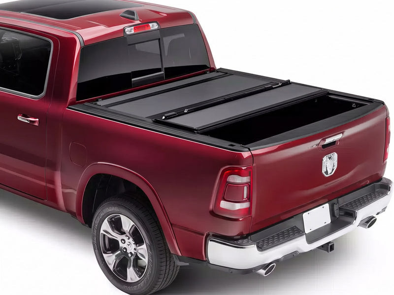 BAK BAKFlip MX4 hard folding tonneau cover in matte black closed over the bed of a dark red Ram 1500 Laramie pickup shown from a rear three-quarter angle