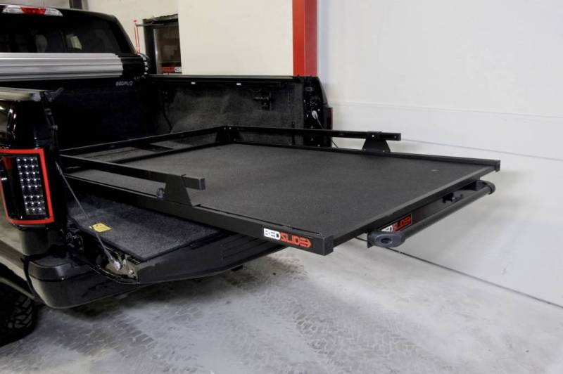 BEDSLIDE 1000 Classic cargo slide in Black Edition finish extended out over the open tailgate of a black pickup