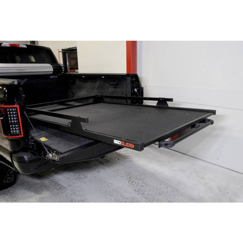 BEDSLIDE 1000 Classic cargo slide in Black Edition finish extended out over the open tailgate of a black pickup