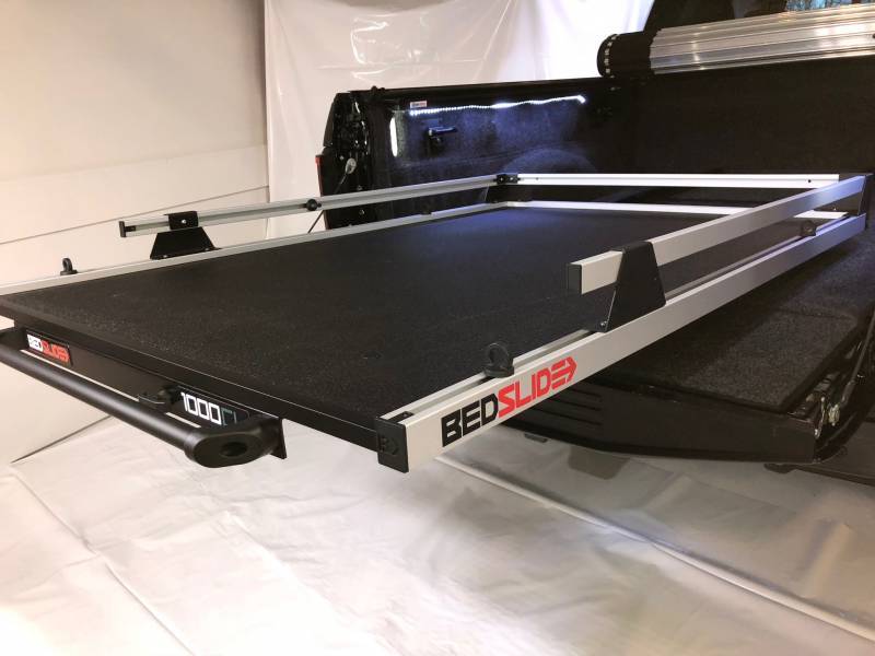 BEDSLIDE 1000 Classic cargo slide in Silver finish angled out of a pickup bed with the 1000 badge visible