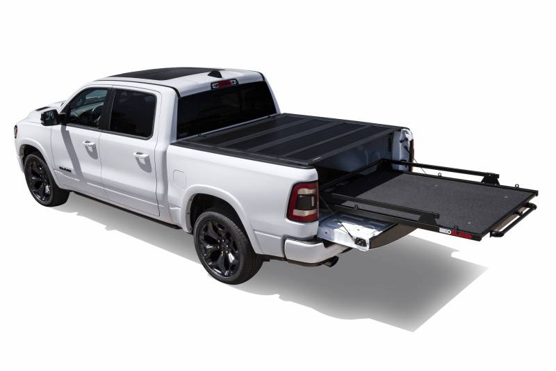 White Ram 1500 with a BEDSLIDE MAX Extension cargo slide in Black Edition finish partly extended past the tailgate