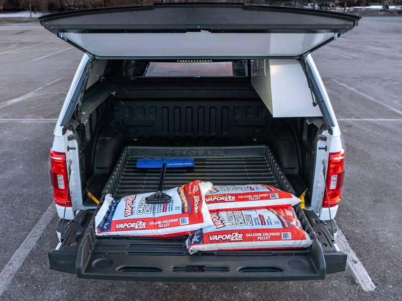 BEDSLIDE 500Go tray rolled out with bagged cargo in a capped pickup bed