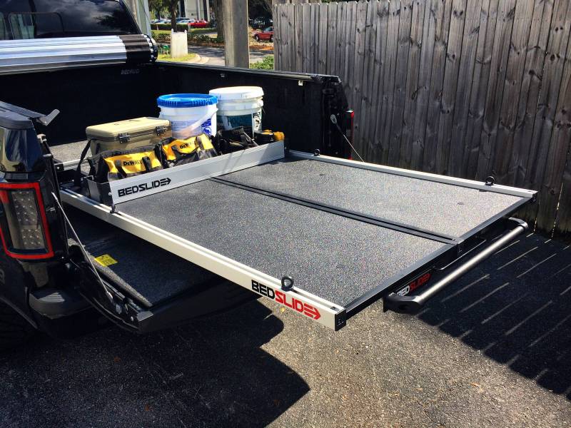 Silver BEDSLIDE extended from a truck bed with the deck divider placed across the deck separating the load