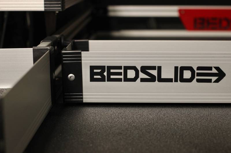 Silver BEDSLIDE BEDBIN deck divider sitting on a slide deck, photographed from the side