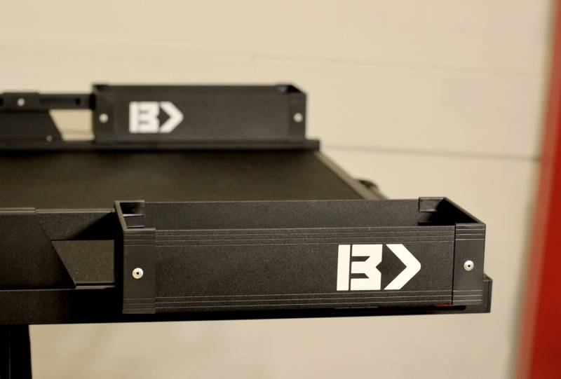 Black Mini Kix bin mounted outboard on the BEDTRAX rail of a Black Edition BEDSLIDE