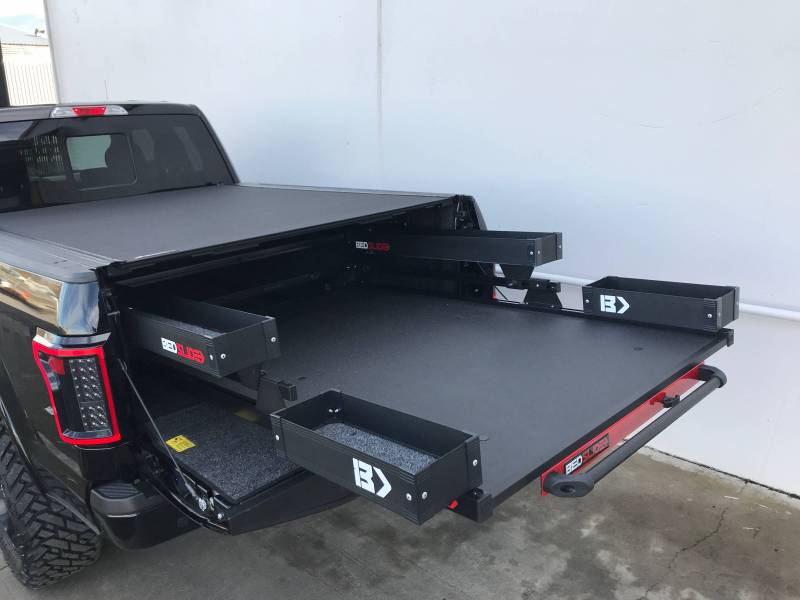 Black Edition BEDSLIDE extended from a truck bed with the black Side Kix bins fitted. The Mini Kix bins also shown are a separate product and are not included with this Side Kix kit.