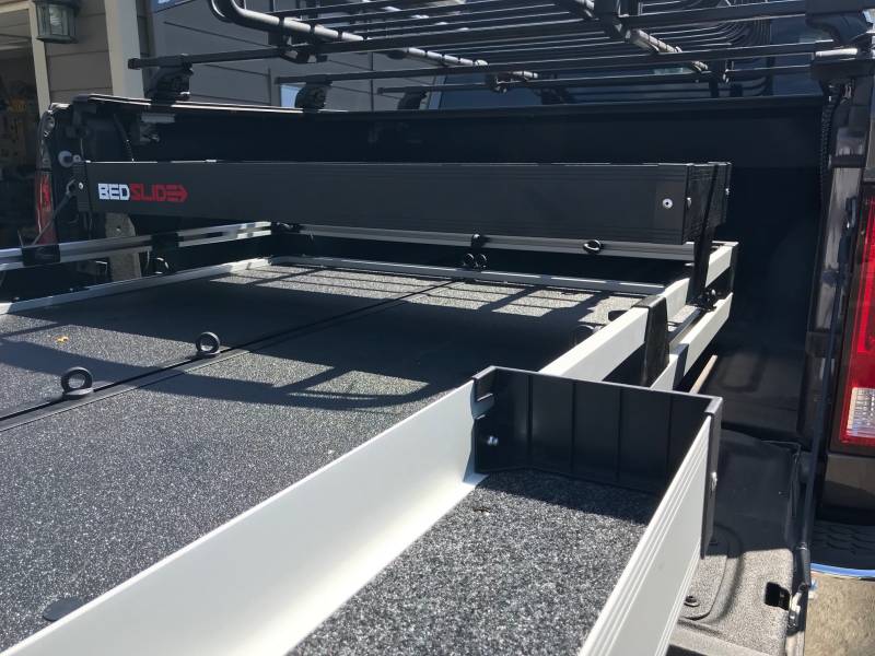 Looking into a truck bed from the tailgate with the black upper tray mounted above the BEDSLIDE deck