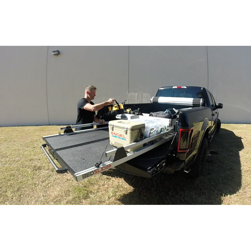 Person loading gear into the silver upper tray above an extended BEDSLIDE deck