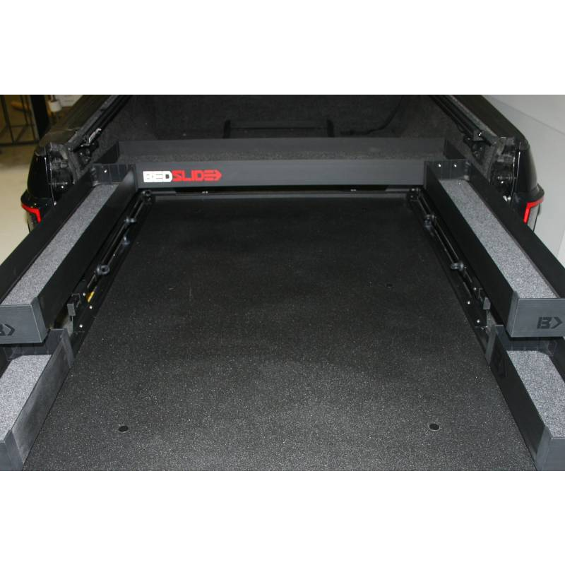 Black Edition BEDSLIDE upper BEDBIN tray mounted across the headboard end of a slide deck, viewed from the tailgate