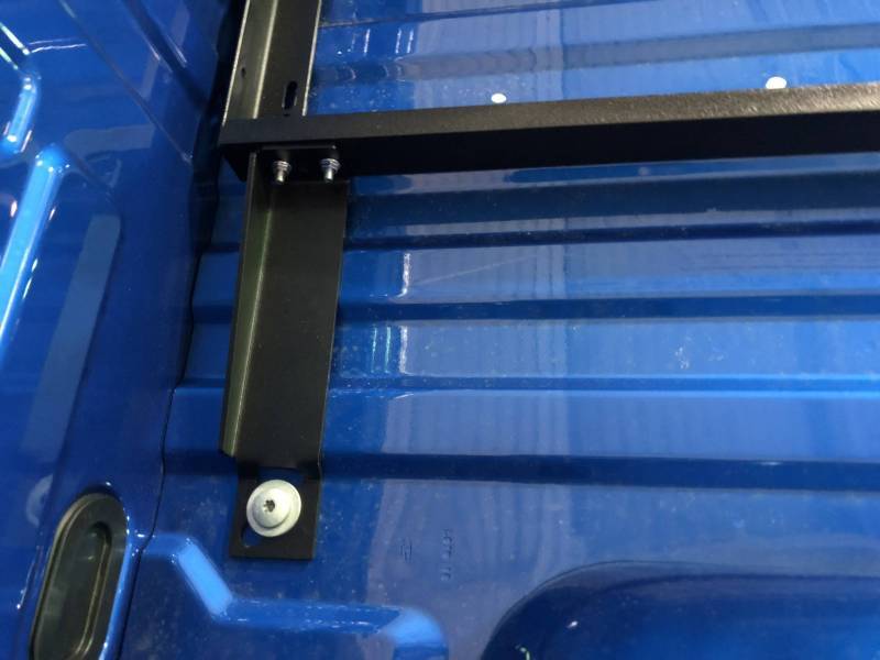 BEDSLIDE no-drill mounting bracket fitted vertically against the side wall of a blue Ford truck bed and bolted at the floor