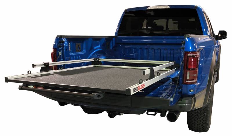 A BEDSLIDE cargo slide shown extended from the bed of a blue Ford pickup, illustrating what these brackets support. The BEDSLIDE is not included with this kit