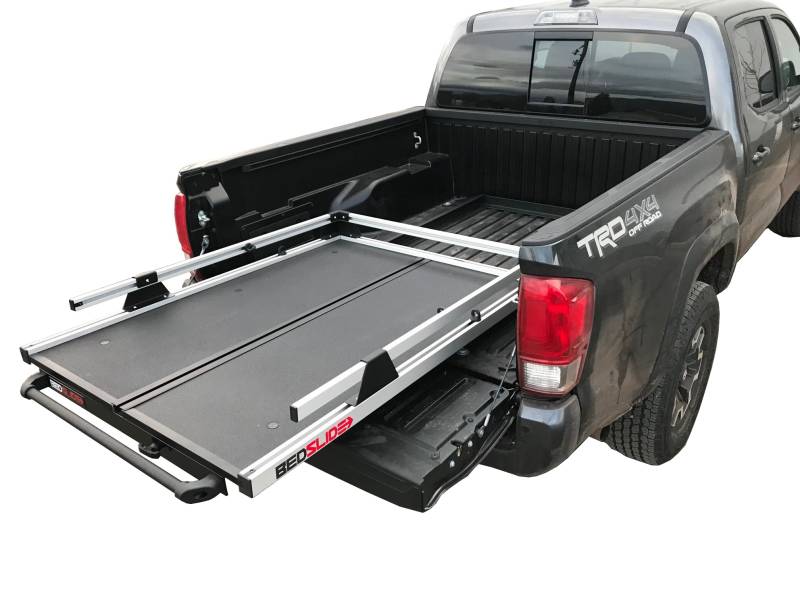 A BEDSLIDE cargo slide shown extended from the bed of a Toyota Tacoma, illustrating what these brackets support. The BEDSLIDE is not included with this kit