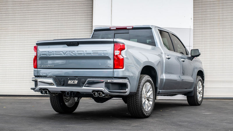 Borla ATAK Cat-Back Exhaust System installed on a Chevrolet Silverado 1500: A gray Chevrolet Silverado 1500 seen from the rear quarter with dual exhaust tips on each side and a Borla plate