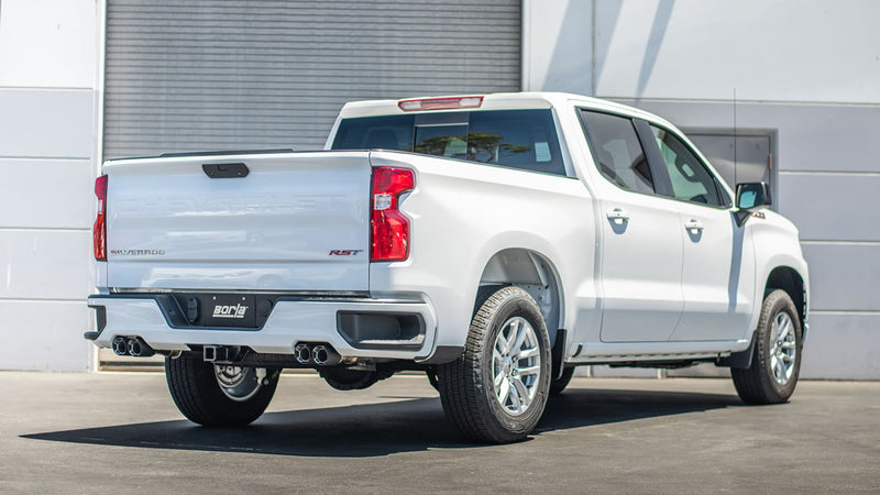 Borla ATAK Cat-Back Exhaust System installed on a Chevrolet Silverado 1500: A white Chevrolet Silverado 1500 RST seen from the rear quarter with dual exhaust tips on each side and a Borla plate