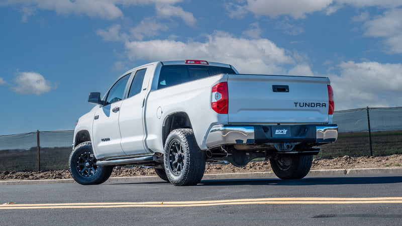 Borla ATAK Cat-Back Exhaust System installed on a Toyota Tundra: white Toyota Tundra double cab seen from the rear quarter on a waterfront lot with exhaust under the rear bumper