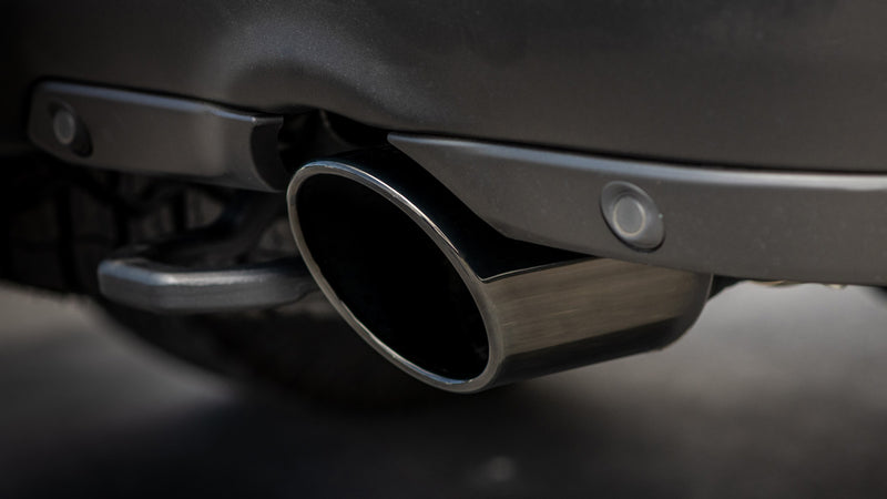 Borla Exhaust Tip Kit: A black chrome angle-cut exhaust tip installed below a dark gray rear bumper next to a tow hook