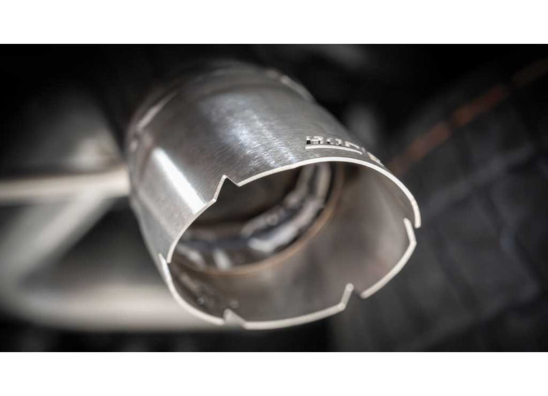 Close-up of the Borla S-Type Cat-Back Exhaust System: close-up of a brushed stainless exhaust outlet with a notched edge and an etched logo against a dark background