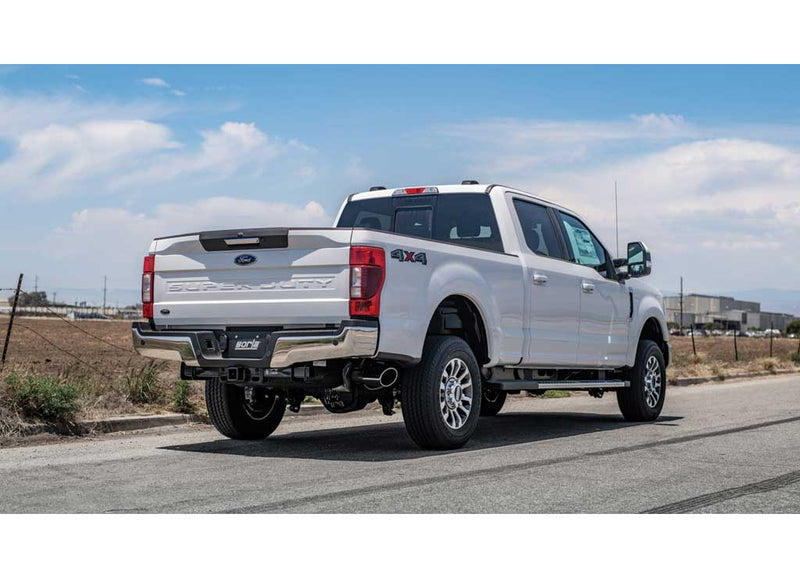 Borla S-Type Cat-Back Exhaust System installed on a Ford F-250 Super Duty: white Ford F-250 Super Duty 4x4 crew cab seen from the rear quarter with a Borla plate and side-exit tip