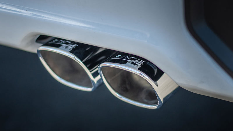 Borla Touring Cat-Back Exhaust System on a vehicle: A close-up of twin polished Borla exhaust tips exiting beneath a white rear bumper