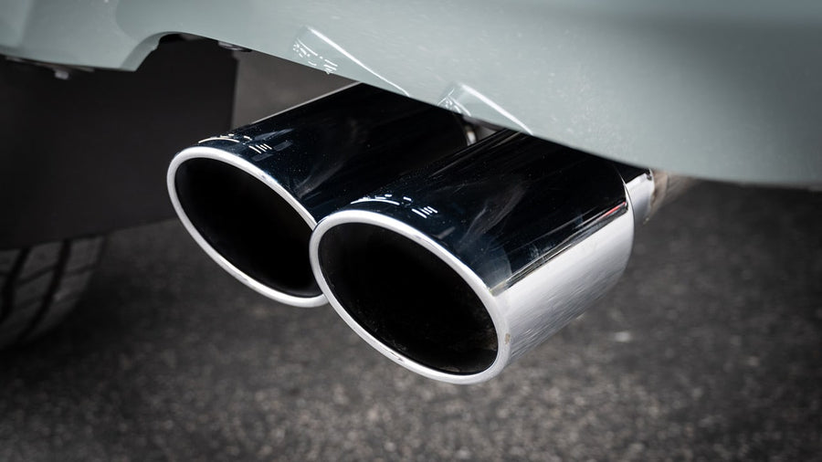 Cat-Back Exhaust Systems by Borla: Close-up of two polished stainless exhaust tips side by side under a gray rear bumper.