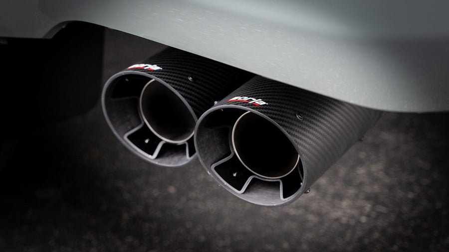 Cat-Back Exhaust Systems by Borla: Close-up of two carbon fiber exhaust tips with Borla logos side by side under a gray rear bumper.
