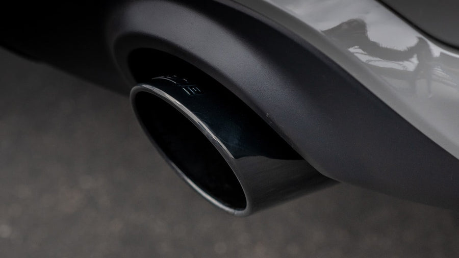Cat-Back Exhaust Systems by Borla: Close view of a black chrome round exhaust tip exiting below a gray rear bumper.