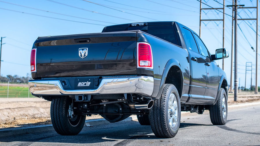Cat-Back Exhaust Systems by Borla: Black Ram heavy-duty crew cab seen from the rear quarter with a Borla plate and the side-exit tip ahead of the rear wheel.