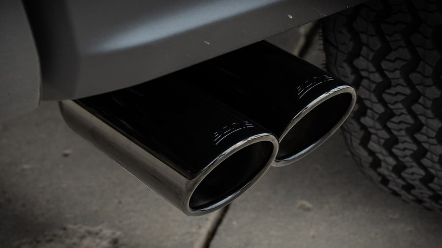 Cat-Back Exhaust Systems by Borla: Close view of dual black chrome tips exiting ahead of a rear tire.