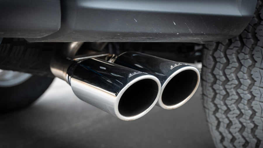 Cat-Back Exhaust Systems by Borla: Close view of dual polished tips with etched Borla lettering exiting ahead of a rear tire.