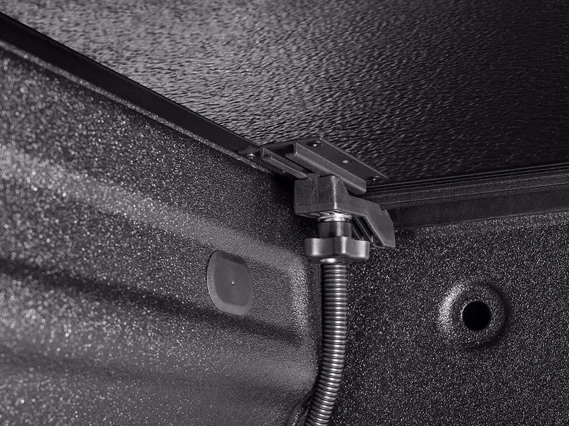 Close-up of the Select clamp assembly and flexible drain hose where the rail meets the bed wall.