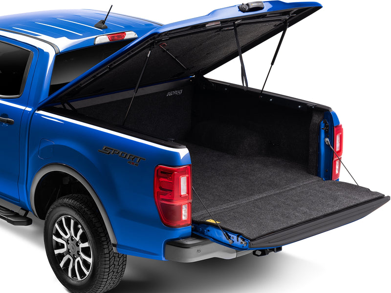 UnderCover Elite LX one-piece tonneau cover raised with the tailgate down, rear three-quarter view looking into the lined bed.