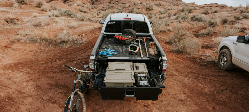 Black DECKED Battle Mat on a midsize DECKED Drawer System deck in a pickup bed with gear laid out and a drawer open