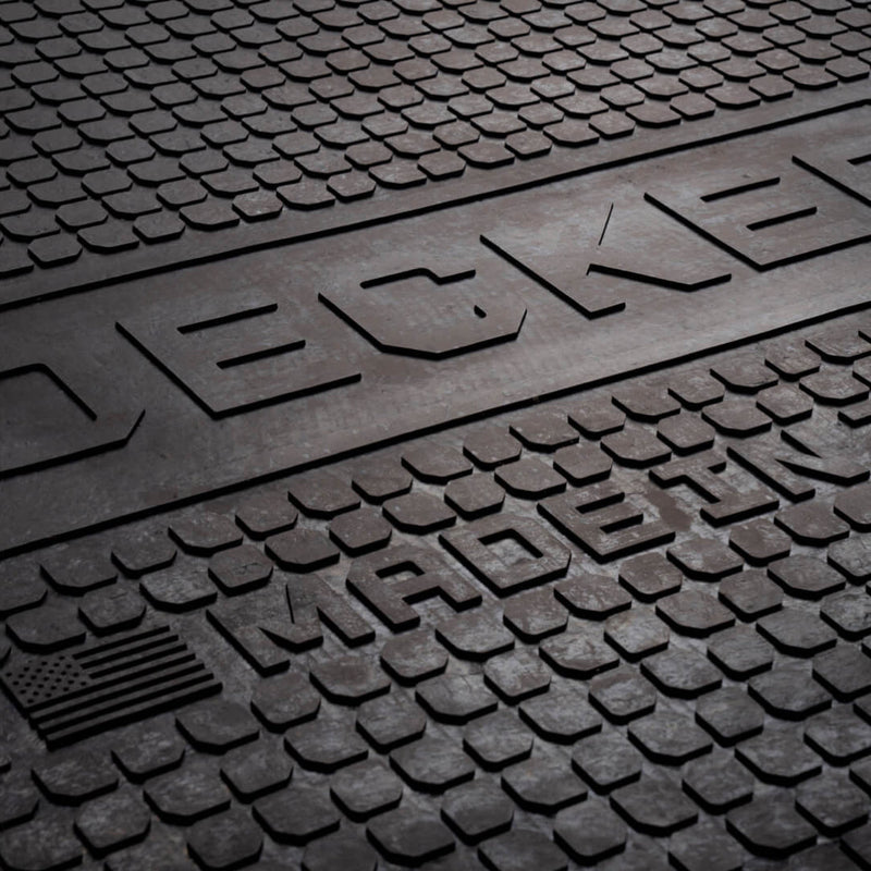 Close-up of the DECKED Battle Mat surface showing the square rubber nubs, the DECKED logo and the molded United States flag with MADE IN THE USA
