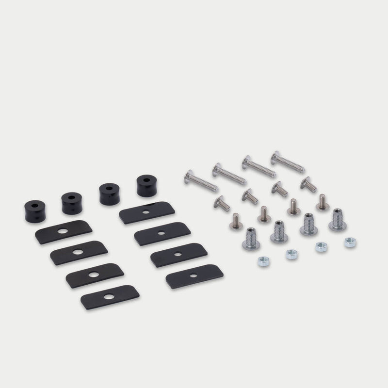 DECKED D-co Case Mounting Kit for CargoGlide laid out in studio: eight black backing plates, four black spacers, stainless bolts, threaded inserts and hex nuts